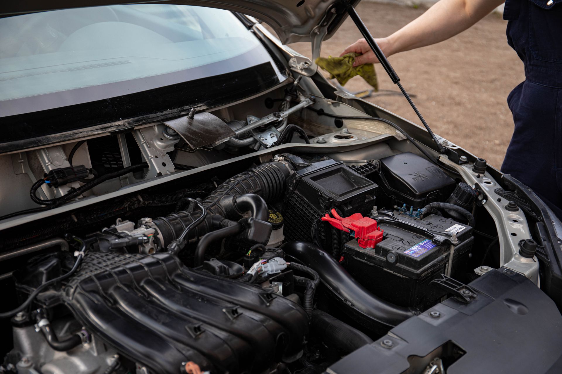 A car repair technician checking the battery in Bossier City