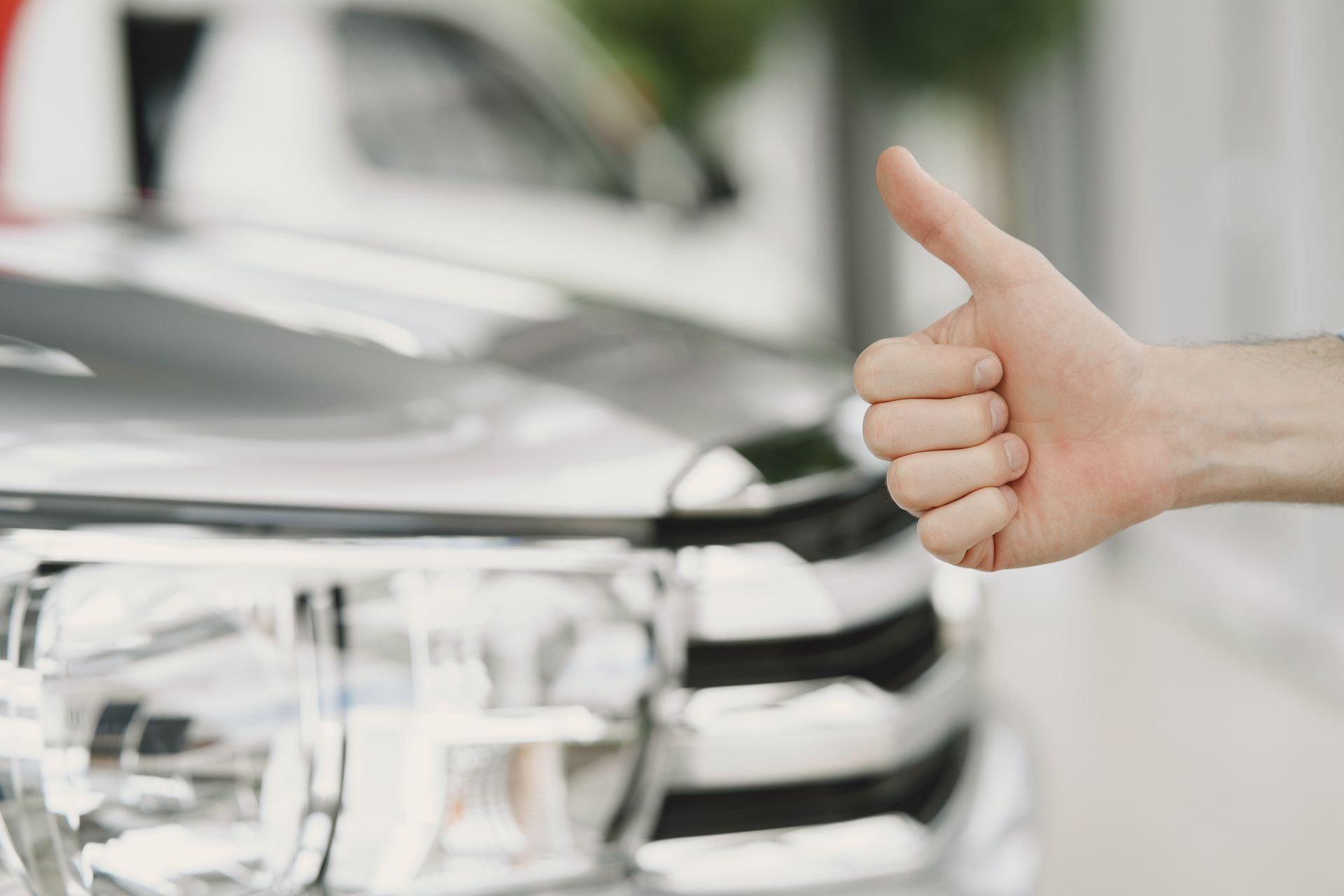 A man holding a thumb up at a car repair shop in Bossier City