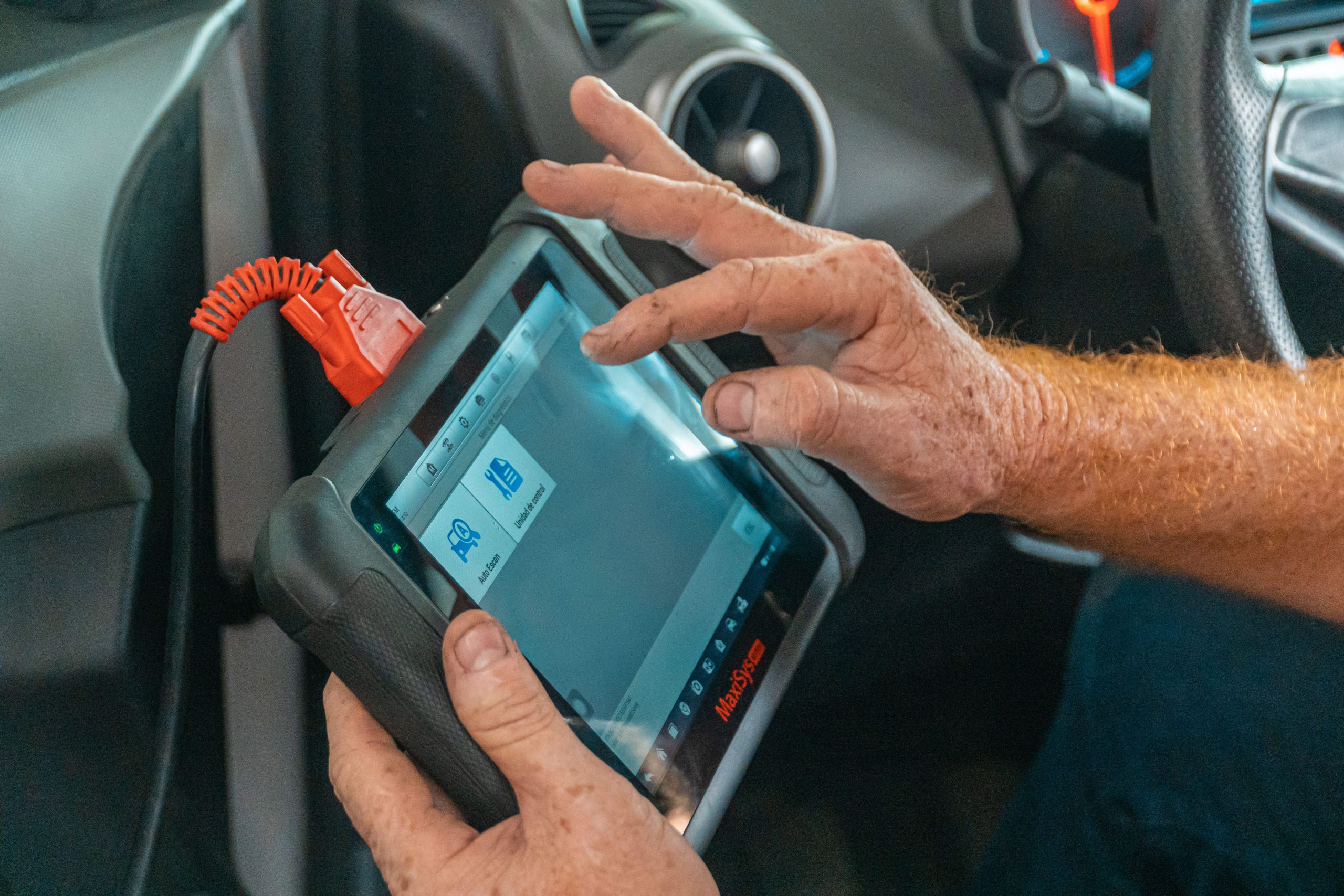 A car repair technician viewing engine data on a device