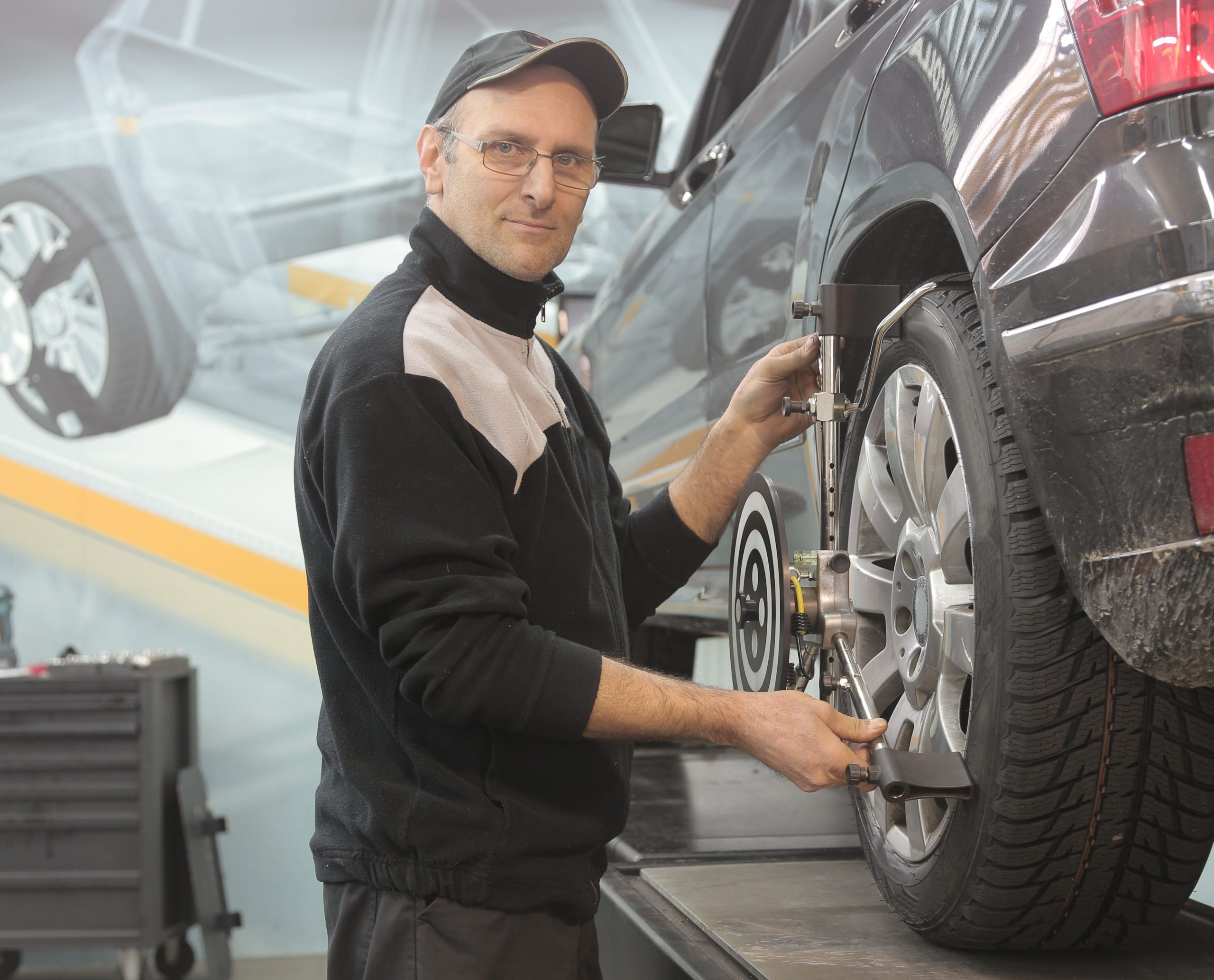 Mechanic performing wheel alignment on a car in a car repair shop in Bossier City