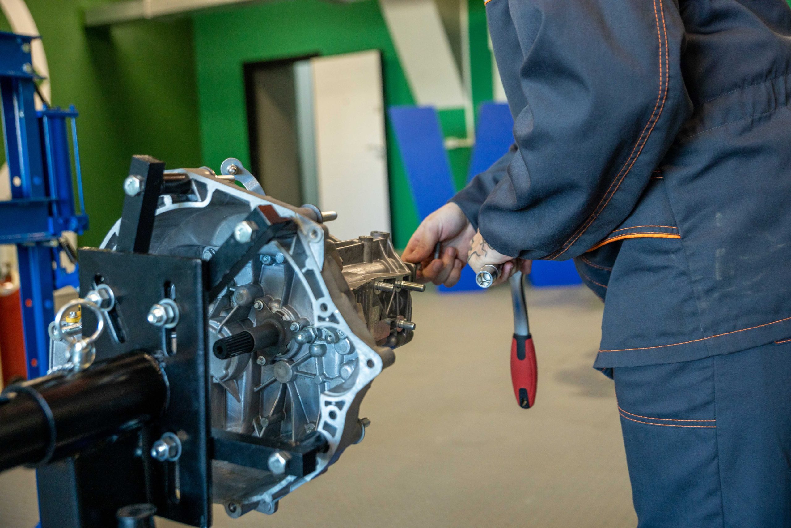 Mechanic using tools to repair a car transmission in an indoor workshop in Bossier City