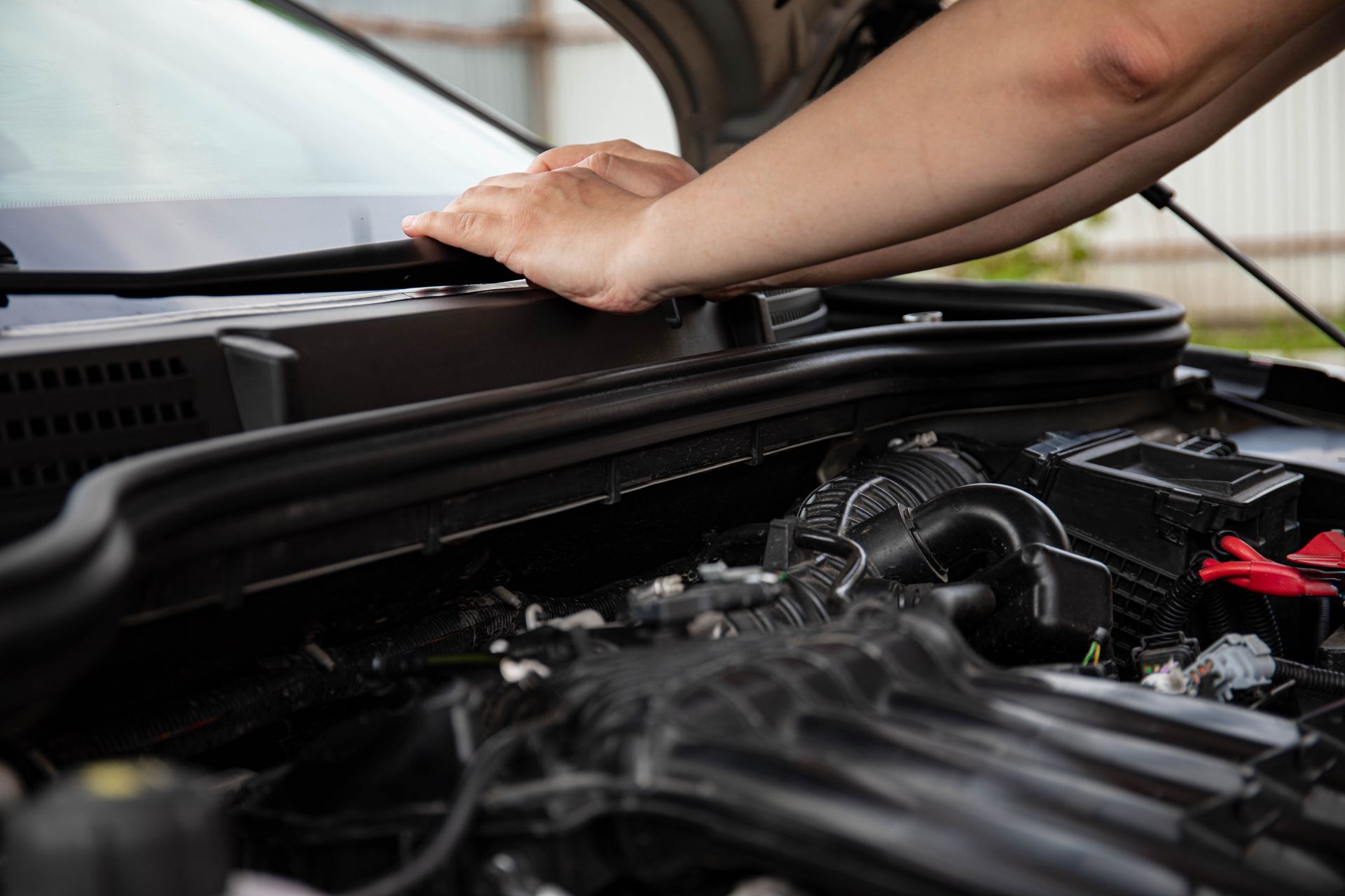 A car repair technician standing over an engine in Bossier City