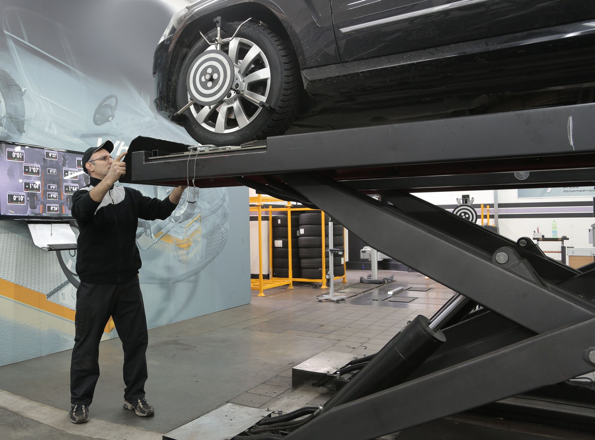 An auto repair shop technician handling wheel alignment in Bossier City